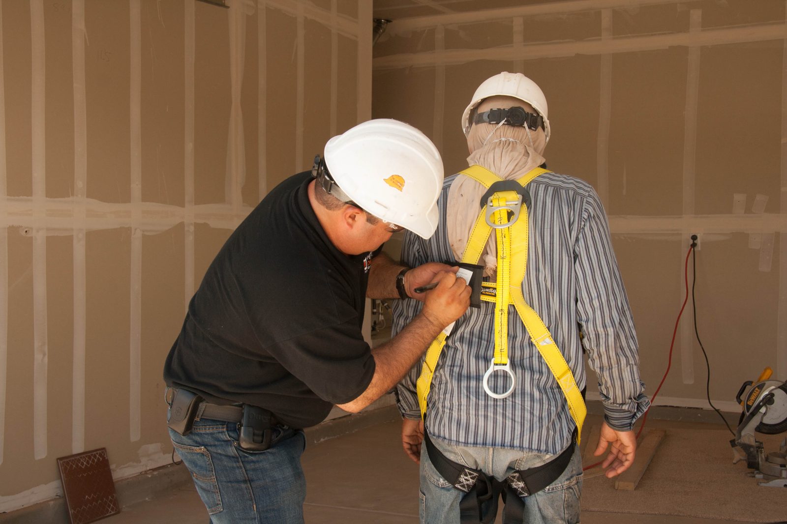 Trabalhador da construção civil utilizando cinto de segurança (talabarte)