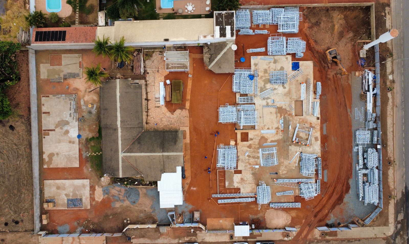 Vista aérea de canteiro com estruturas metálicas (light steel frame) organizadas para montagem