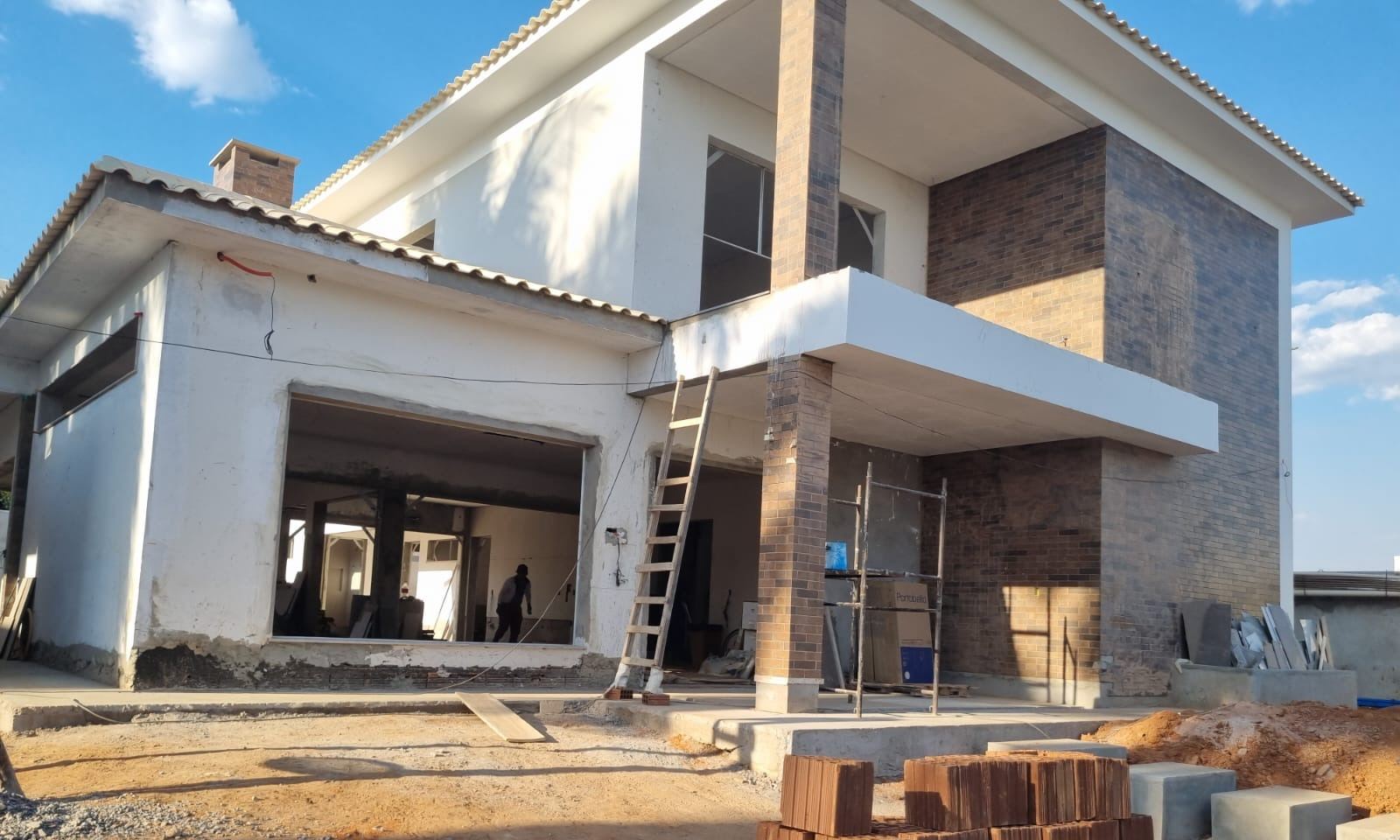 Fachada de residência de alto padrão em execução, com revestimento em tijolo aparente